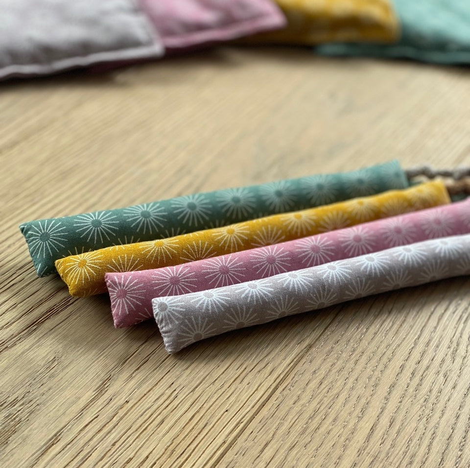 Baby-Kaustangen aus Baumwolle mit Blumen bzw. Sonnenmuster in Farben gruen rosa gelb und lila – weiche Zahnungshilfe für Säuglinge.