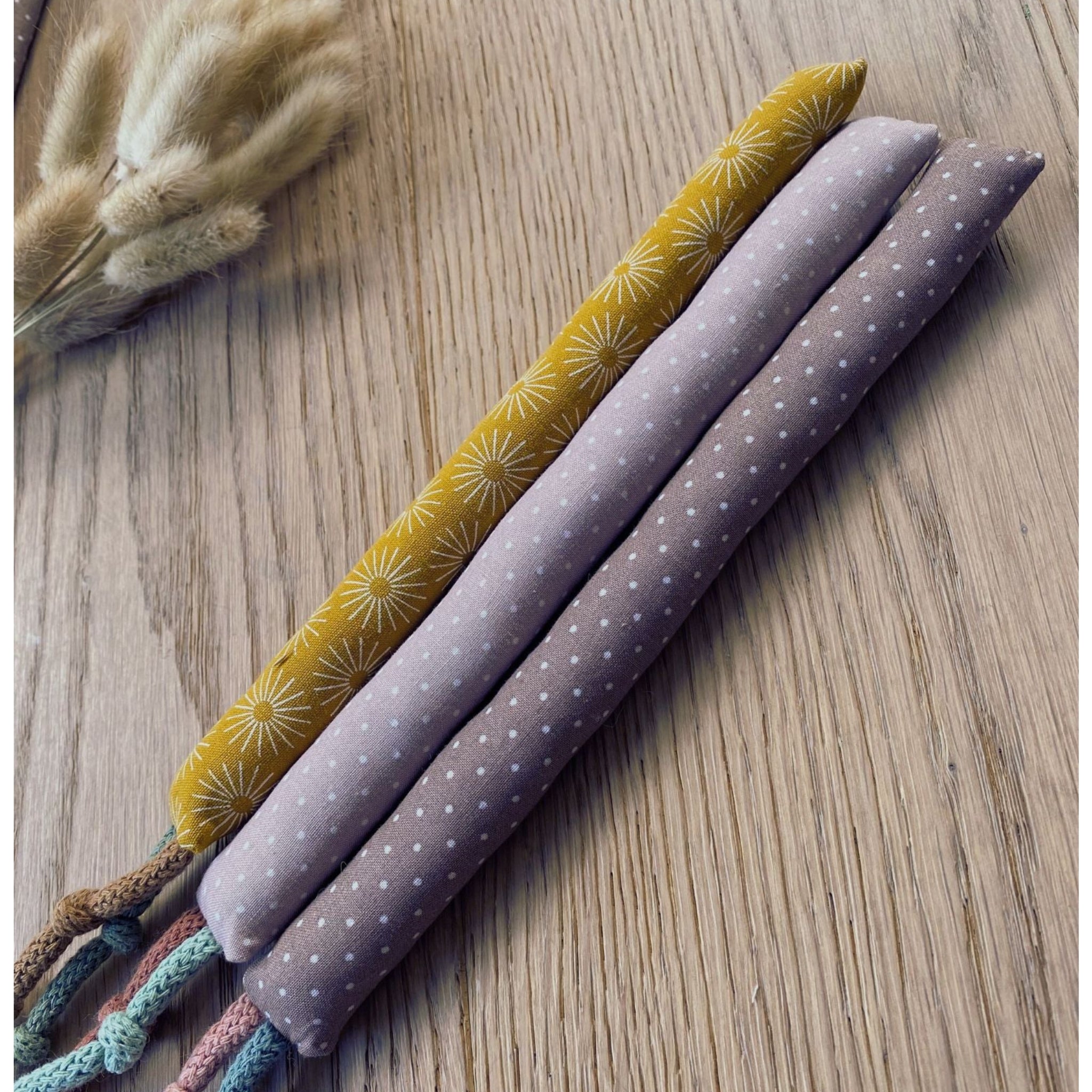 Unterschiedliche Muster der Baby Kaustangen in unterschiedlichen Farben senfgelb beige und braun mit minimalistischem Sonnen-Muster und Punkten (Boho-Stil)